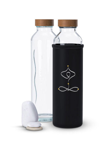 Dos botellas de cristal Flaska con tapas de madera; una tiene una funda negra con un diseño de pose de yoga.