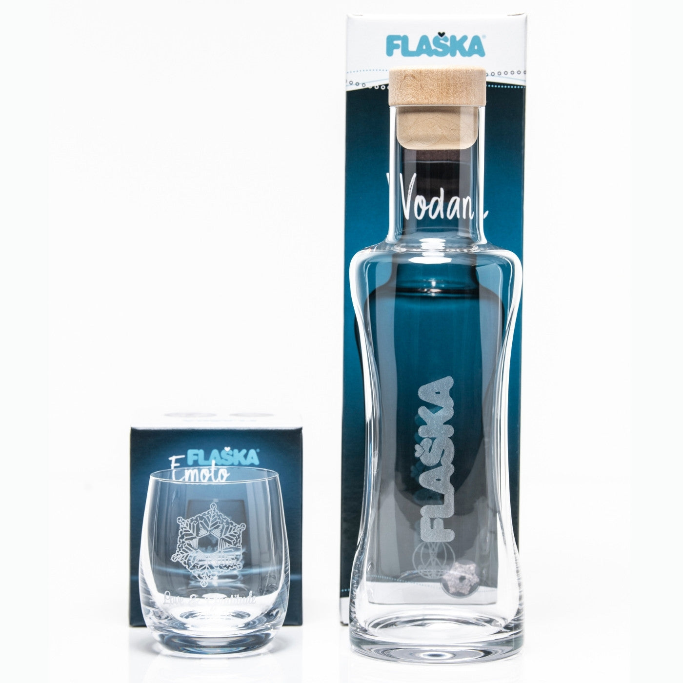 vaso de agua de cristal emoto junto a jarra de cristal de agua Flaska delante de sus cajas